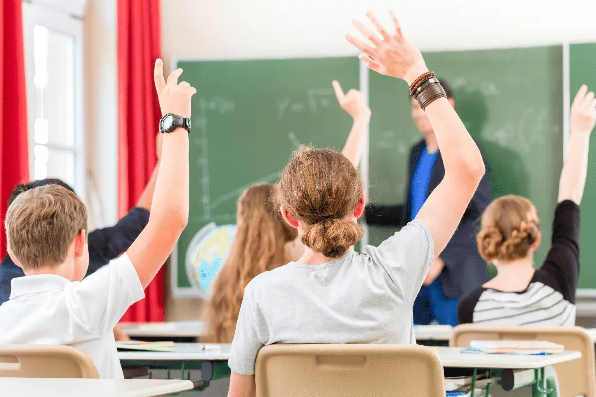 studenti alzano la mano durante una lezione in classe