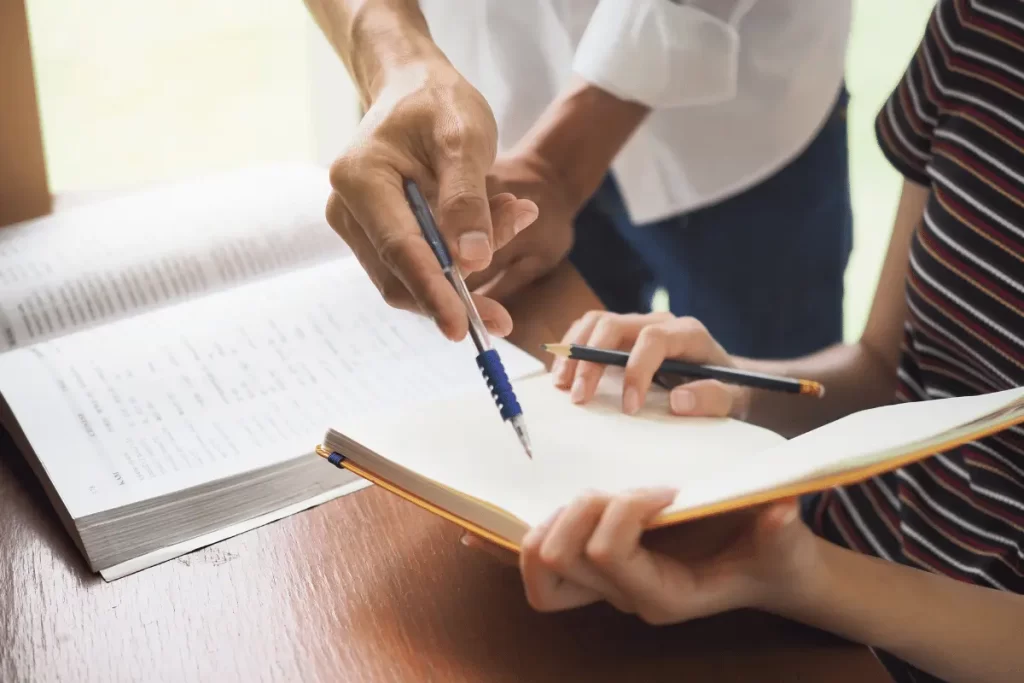 docente di sostegno spiega un esercizio ad un'alunna 