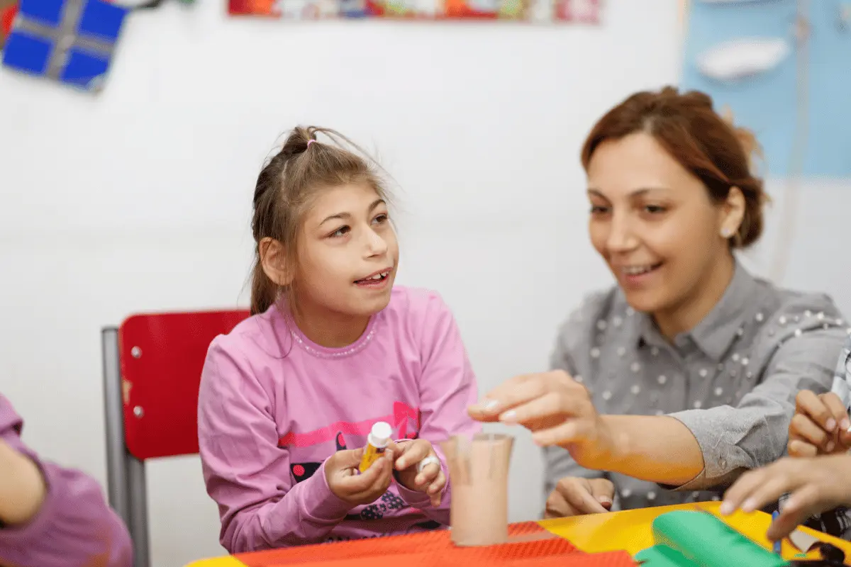insegnante di sostegno con un'alunna disabile