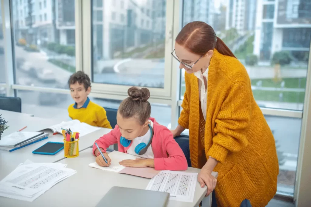 docente di sostegno in classe vicino ad un'alunna