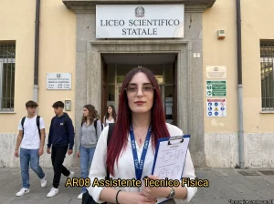 AT davanti ad una scuola. In primo piano la scritta: "AR08 Assistente Tecnico Fisica"